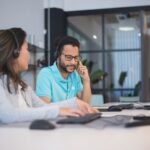 Empresário frustrado olhando para o celular, representando a perda de clientes no atendimento via WhatsApp